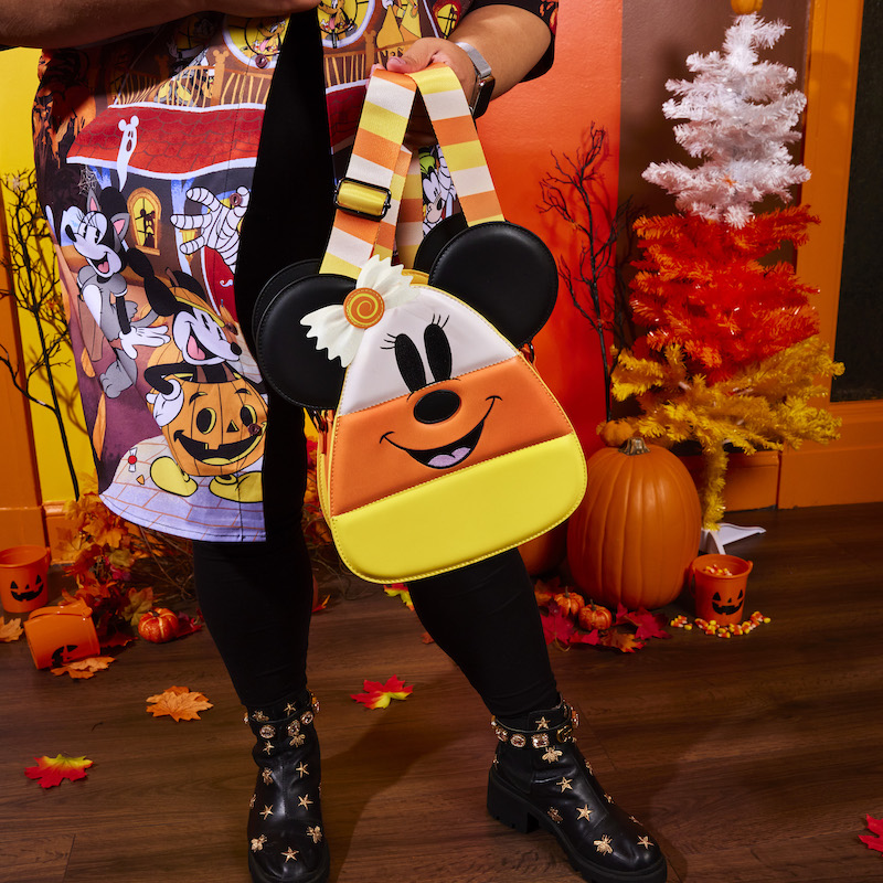 Image of someone holding the Candy Corn Crossbody, showing the Minnie Mouse side of the bag